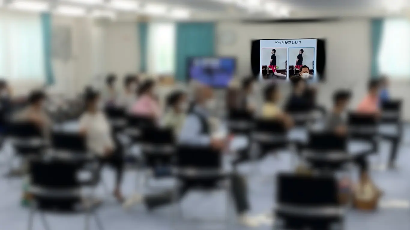 製造業の安全大会で、理学療法士による転倒予防・腰痛予防の参加型研修を受ける従業員たち